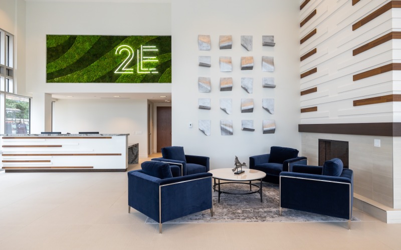 a lobby with seating table and reception desk with a sign over it