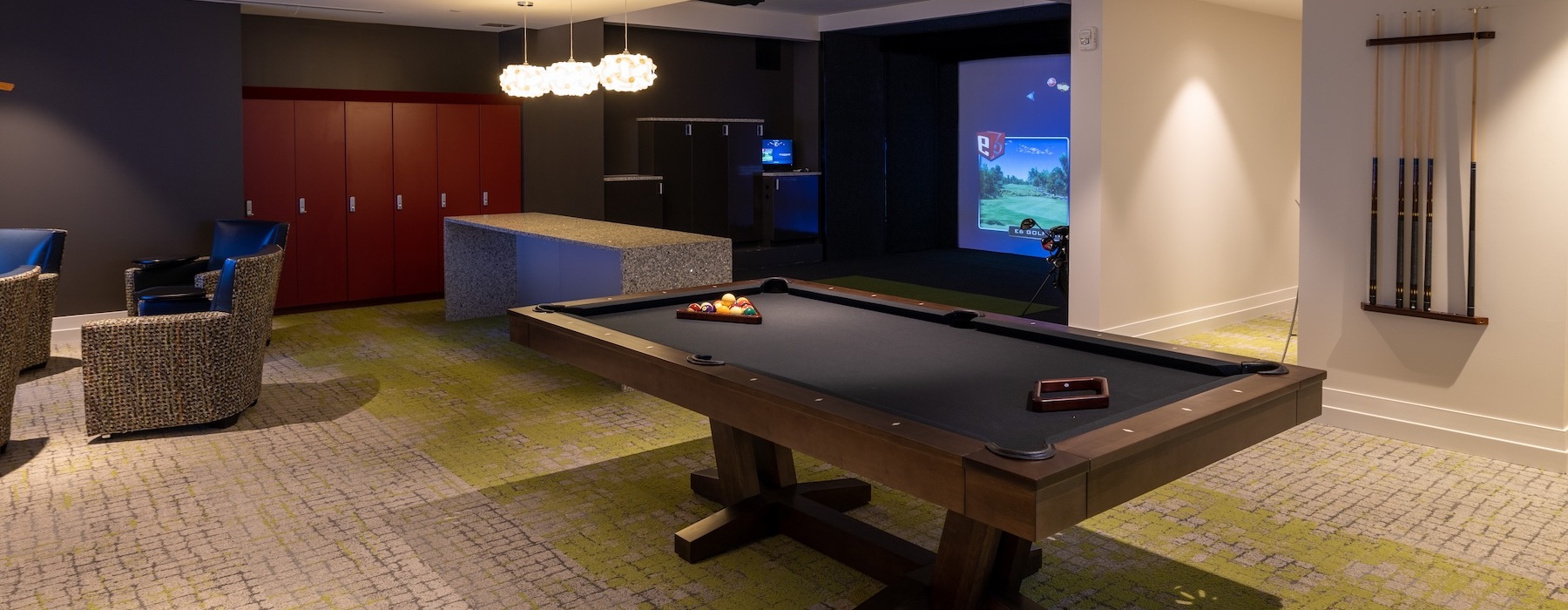 a game room with pool table and golf simulator